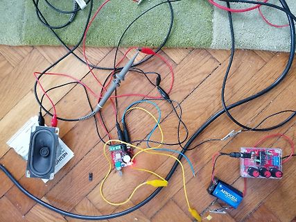 Elektronischer Aufbau mit Lautsprecher, Platinen und Kabeln auf Holzboden