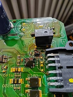 Nahaufnahme einer grünen Leiterplatte mit elektronischen Bauteilen