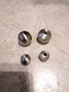 Vier metallische Kugeln mit Gewindeöffnung