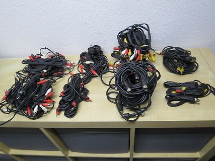 Bündel von Audiokabeln und Adaptern auf einem Tisch