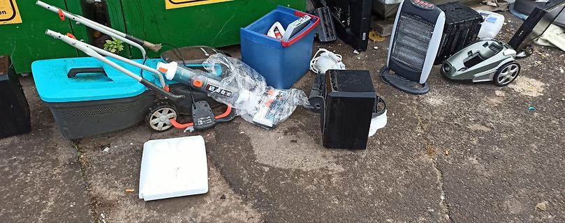 Verschiedene gebrauchte Haushaltsgeräte und Plastikbehälter auf Boden