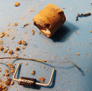 Defektes Bauteil und Krümel auf blauem Untergrund
