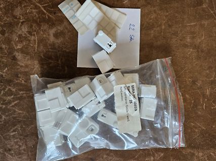 Weiße Kunststoffstecker in Beutel und auf Zettel