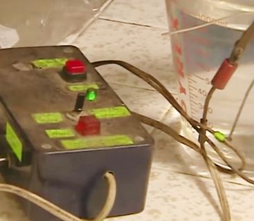 Elektronik-Aufbau mit Gehäuse, Schaltern und Becherglas