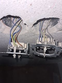 Freiliegende elektrische Leitungen und Steckdosen in Wandöffnung