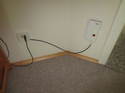 Router und Steckdose an einer Wand