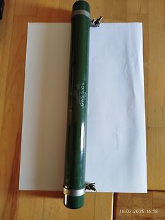Grüne Transportröhre auf weißem Papier