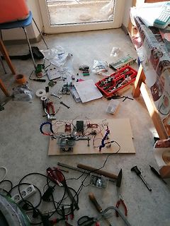 Werkstatt mit Elektronik-Aufbau auf Holzbrett und Werkzeugen