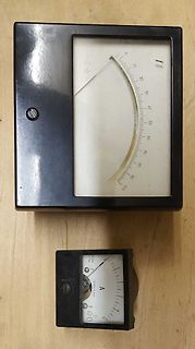 Zwei analoge Amperemeter auf Holzuntergrund