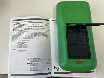 Bedienungsanleitung und Gehäuseteil eines Netzteils
