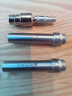 Drei Sonoscan Bauteile auf Holzuntergrund