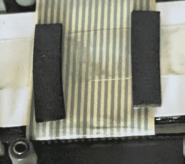 Nahaufnahme von zwei schwarzen Magneten auf gestreiftem Untergrund