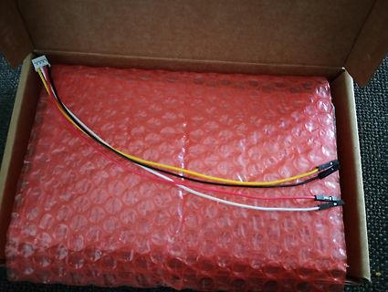Verpacktes Bauteil mit Anschlusskabeln in einem Karton