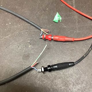 Abgeschnittene Kabel und Stecker auf Untergrund