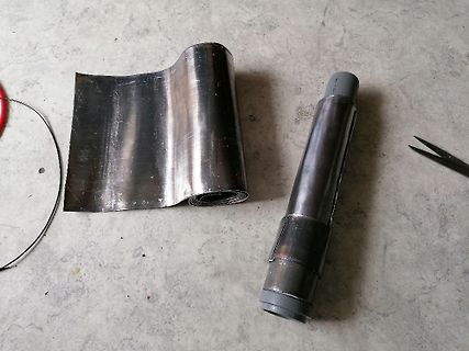 Metallfolie und Metallrohr auf Werkstattboden