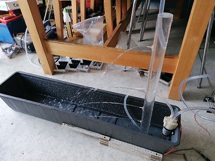 Aufbau einer Wasserpumpe mit Schläuchen und Behälter