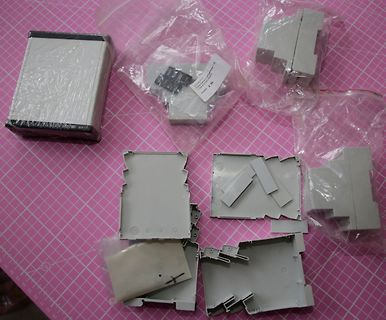 Graue Kunststoffgehäuse und Bauteile in Plastikverpackungen
