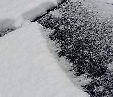 Schneedecke auf einer dunklen Oberfläche