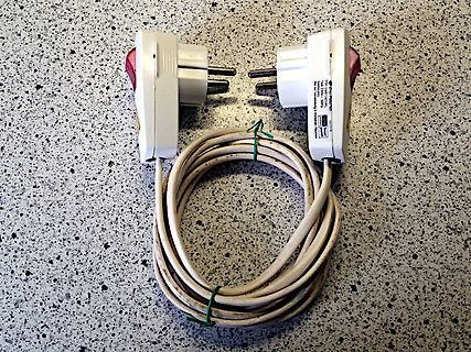 Zwei Netzstecker mit Kabel auf Tischoberfläche