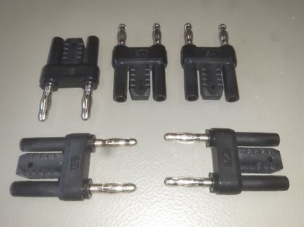 Vier schwarze Steckverbinder mit Metallstiften