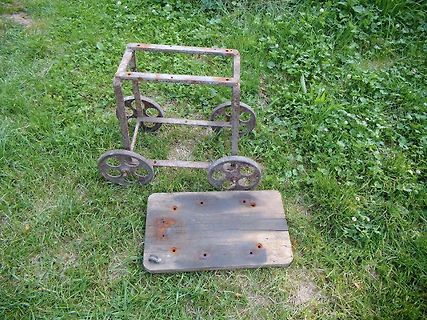 Metallgestell mit Rädern und Holzbrett auf Gras