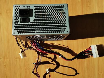 PC-Netzteil mit Kabeln auf Holzuntergrund