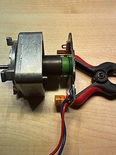 Elektronikbauteil mit Kabeln und Klemmen auf Holzuntergrund