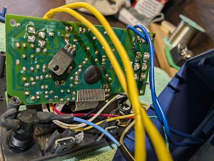 Geöffnete Elektronik mit Leiterplatte und bunten Kabeln