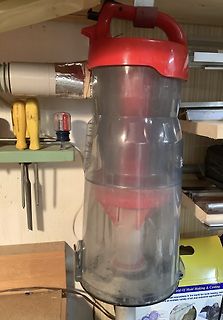 Durchsichtiger Behälter eines Staubsaugers in Werkstatt