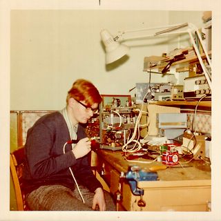 Person an einem Arbeitstisch mit Elektronikmessgeräten