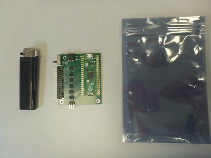 Raspberry Pi Pico 2 neben Feuerzeug und Beutel