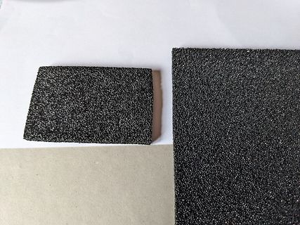 Nahaufnahme von zwei schwarzen, körnigen Oberflächenmaterialien