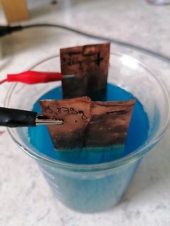 Elektrolyse-Versuch mit Kupferplatten in blauer Lösung