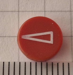Rotes Bauteil mit weißem Dreieck auf Millimeterpapier