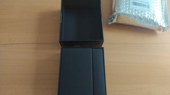 Schwarze Verpackung und silberne Folie auf Holztisch