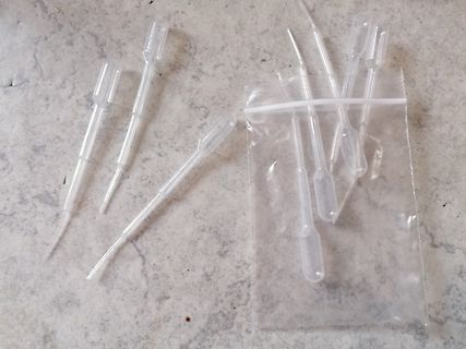Mehrere Kunststoff-Pipetten und ein Plastikbeutel