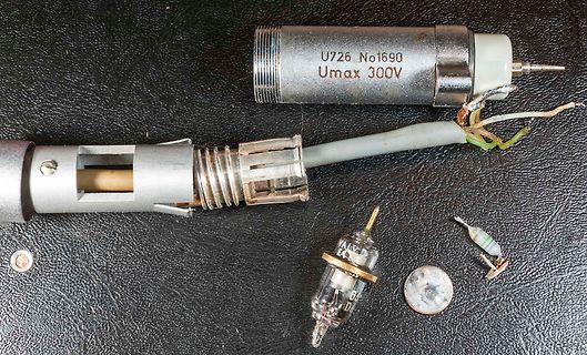 Defektes Netzteil mit beschädigtem Kabel und Bauteilen