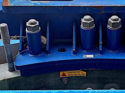 Blaue Metallkonstruktion mit Bolzen und Warnhinweis
