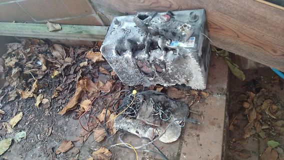 Beschädigte Autobatterie mit Korrosion und Kabeln