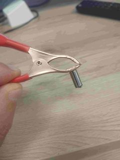 Krokodilklemme hält Metallstift