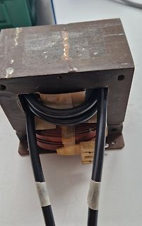 Transformator mit Kupferwicklungen und schwarzen Kabeln