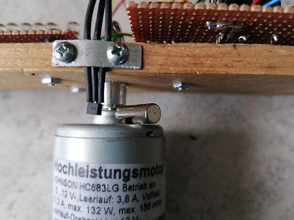 Elektromotor an Lochrasterplatine auf Holzbrett