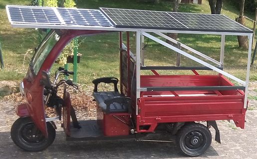 Rotes Elektro-Dreirad mit Solarmodulen auf dem Dach