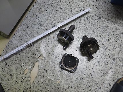 Mechanische Bauteile und Lineal auf Werkstattuntergrund
