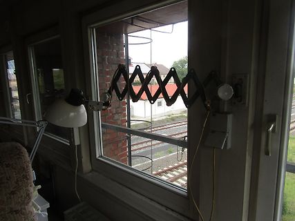 Schreibtischlampe vor einem Fenster mit Blick auf Bahngleise