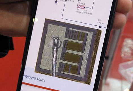 Foto eines Smartphone-Displays mit Schaltplan und Mikrostruktur