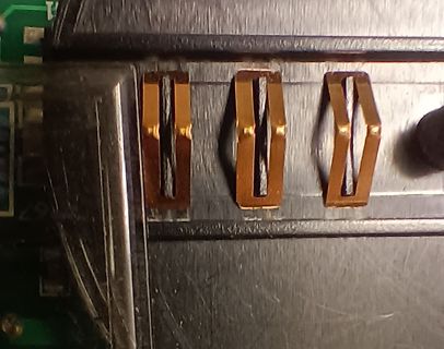 Nahaufnahme von drei kupferfarbenen Metallkontakten