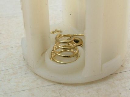 Goldfarbene Feder in weißem Kunststoffgehäuse