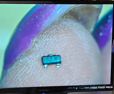 Nahaufnahme eines elektronischen Bauteils auf einem Finger