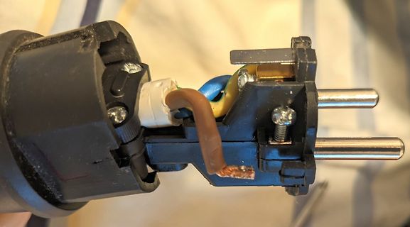 Defekter Netzstecker mit freiliegenden Kabeln
